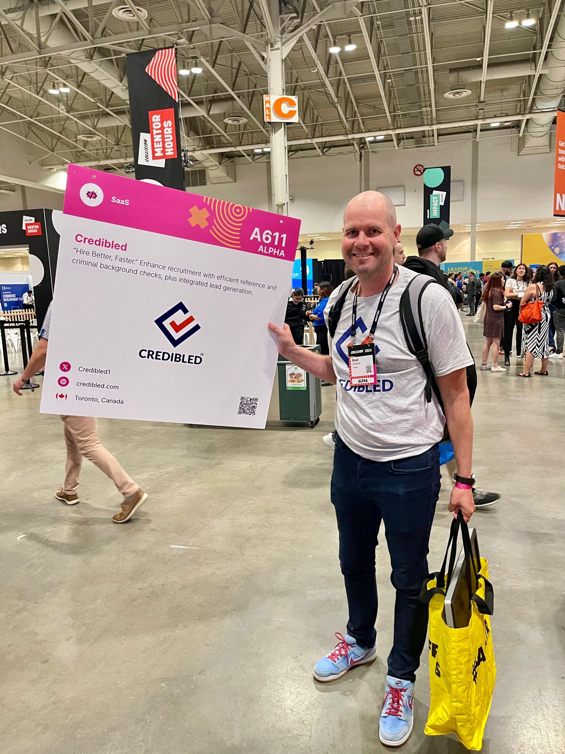 Brad Semotiuk holding the Credibled exhibitor sign at Collision 2024 in Toronto